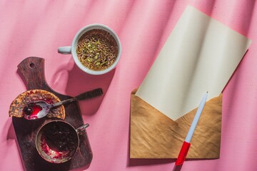 Still life - postal envelope, a sheet of paper for sending a message and a cup of herbal tea on the table