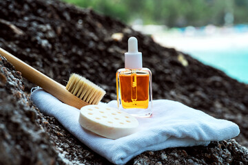 Cosmetic serum with golden particles by the seaside