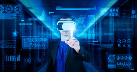 Businessman with headset standing at data center while analyzing financial data. Manager pointing...