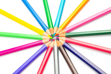 Naklejka premium A vibrant burst of colored pencils arranged in a radial pattern against a white background, showcasing a spectrum of hues. Perfect for art, creativity, and education themes.