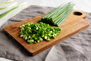 Organic Cut Green Onion Scallions on a Wooden Board, side view. Close-up.