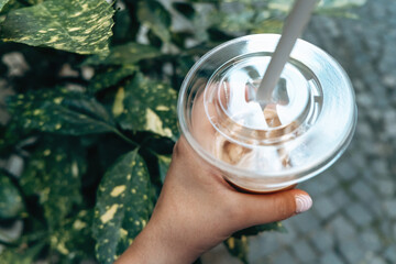 A person drinks a drink in a beautiful natural place surrounded by bright greenery