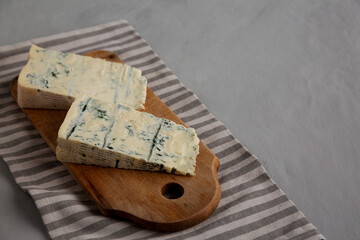 Blue cheese Gorgonzola on a Wooden Board, side view. Copy space.