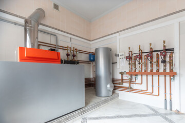 Plakat A modern heating system is installed in the utility room, including a large boiler, a water heater and a complex piping system.