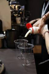 barista llenando una tetera de leche en la cafetería