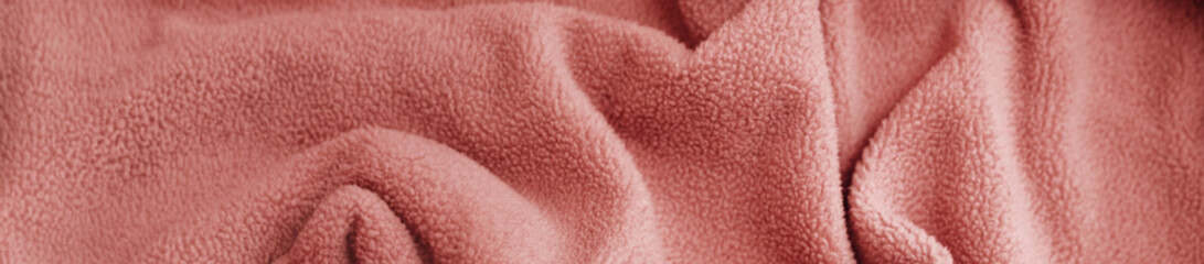 Soft Wavy Fabric Texture in salmon colour .Elegant Decorative Background. Pastel gentle Waves in Light Fabric.Close-up of a soft fabric surface with gentle waves and folds.