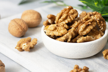 Ripe and fresh walnut kernels in bowl without shell on rustic table, healthy nut food for brain