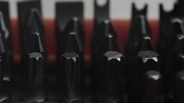 Close-up view of precision screwdriver bits arranged in a row, showcasing the sharp tips and detailed craftsmanship.