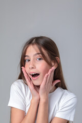 Portrait of a beautiful teenage girl with long hair in black leggings and a top in a photo studio on a white background. Different emotions. Emotional shot. Model. Photo model. Photo session.