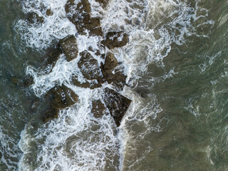  aerial view ocean waves lapping on the rocks