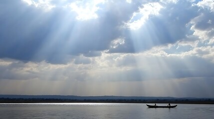 Sunbeams over river boat with Africa.