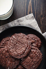 Plate of Triple Chocolate Cherry Cookies with Glass of Milk: Chocolate cherry cookie dessert stacked on a plate with cup of milk on the side