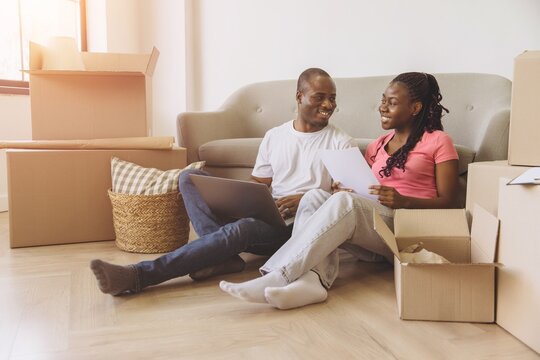 Young African American Couple Organizing Move in New Apartment - Powered by Adobe