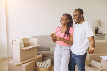 Happy african american couple moving in new apartment visualizing furniture placement