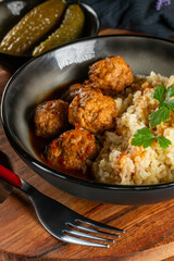 Meatballs pork and mashed potatoein paprika gravy served with groats bulgur.