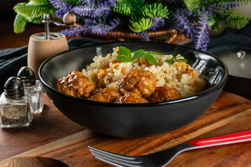 Meatballs pork and mashed potatoein paprika gravy served with groats bulgur.