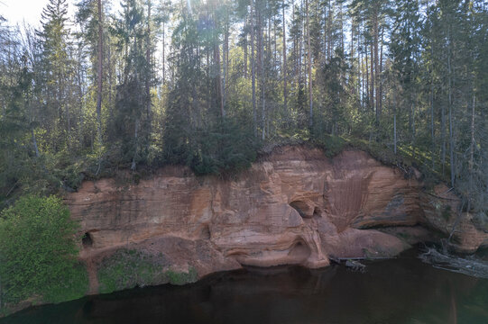 Red cliffs on Salaca river in Latvia at summer.  Cliffs in a Skanaiskalns Nature Park on Salaca river in Mazsalaca, Latvia