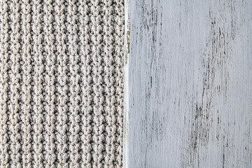 fragment of white wooden cutting board on beige large knit background