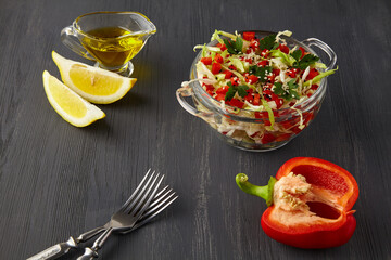 cabbage salad with bell pepper and parsley, sprinkled with sesame seeds, dressed with olive oil and lemon on a black wooden table