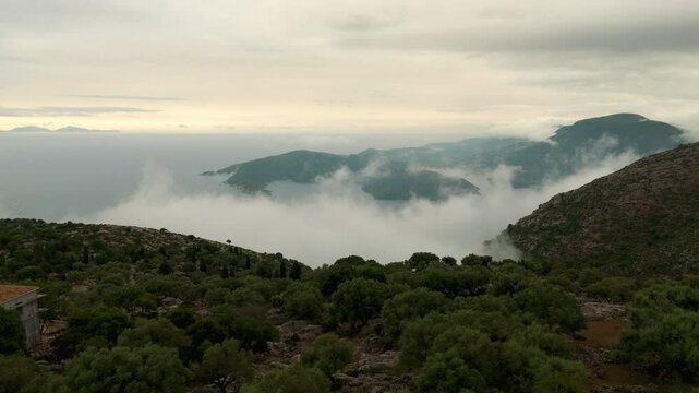 Aerial drone view of Ithaca flying through clouds foggy morning Greece Europe cinematic Vathy islands Ionian Mediterranean Sea 