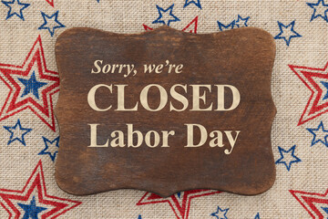 Fototapeta na wymiar Closed Labor Day sign with retro USA red, white and blue star and stripes on weathered wood