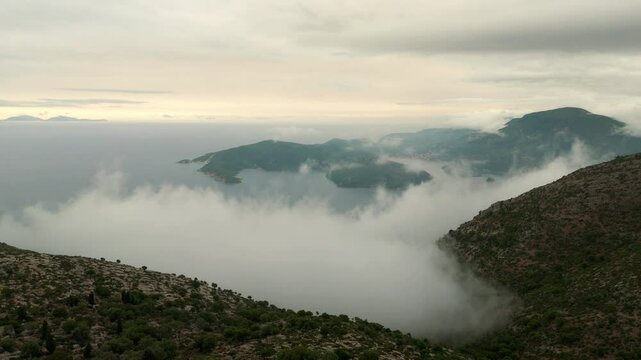 Aerial drone view of Ithaca flying through clouds foggy morning Greece Europe cinematic Vathy islands Ionian Mediterranean Sea 