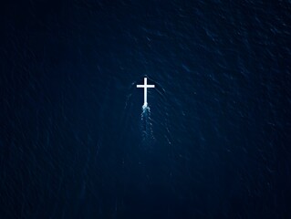 A lone white cross floats serenely atop the vast expanse of water, creating a powerful and evocative scene with simple imagery.