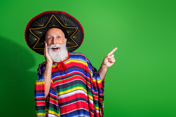 Elderly man in vibrant Mexican attire with sombrero and poncho, gesturing enthusiastically against...