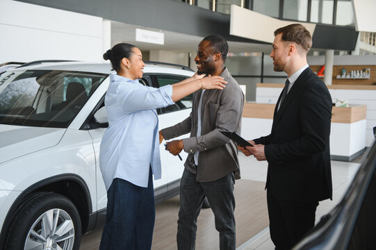 African american couple buying new car with salesman assistance