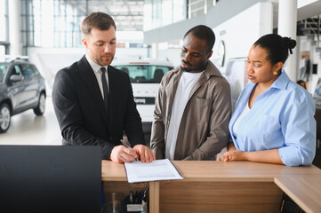 African american couple consulting with car salesman