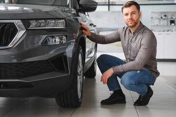 Customer choosing new car in dealership showroom