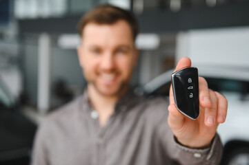 Customer showing new car key in dealership showroom