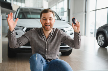 Happy customer showing car keys in dealership showroom