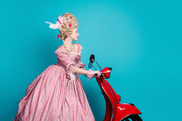 Photo of charming lady princess wear baroque pompous gown driving moped isolated on blue color...