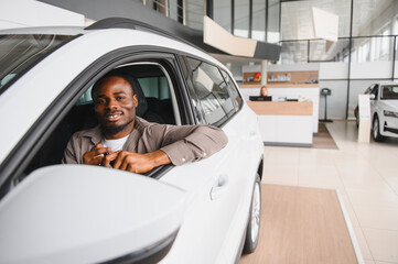 Fototapeta premium Happy customer holding car keys sitting in new car at dealership