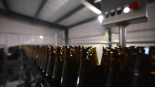 Automated beer bottle filling and capping process in modern brewery facility.