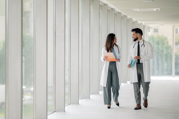 Doctors walking and talking in hospital corridor