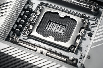 High-resolution macro image showing a close-up view of an empty CPU socket on a modern computer motherboard. Detailed view of metal contacts and electronic components.