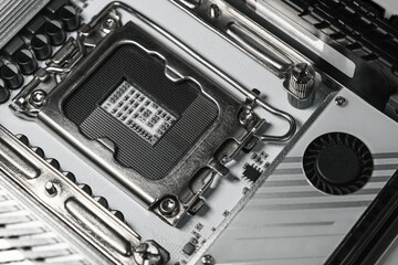 High-resolution macro image showing a close-up view of an empty CPU socket on a modern computer motherboard. Detailed view of metal contacts and electronic components.