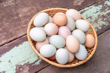 Brown chicken eggs of different shades lie in a wicker basket on a wooden table, creating a rustic still life, a concept of abundance of fresh farm products, 