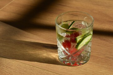 glass of water with lime, cucumber and raspberries