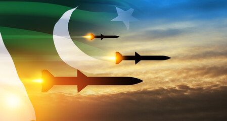 Fired missiles fly to the target. Missiles at the sky at sunset with Pakistan flag.