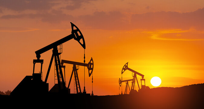 Oil drilling derricks at desert oilfield. The change in oil prices caused by the war. Oil price cap concept.