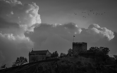 The Lanhoso Castle during Sunset in a Stormy Day with a Flock of Doves Flying, Povoa de Lanhoso, Braga, Portugal.