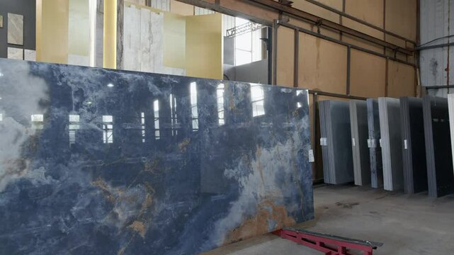 Colorful quartz and porcelain tile stone slab are standing in the factory warehouse. Kitchens and bathrooms countertop selection. Granite slabs are prepared for sale in store yard