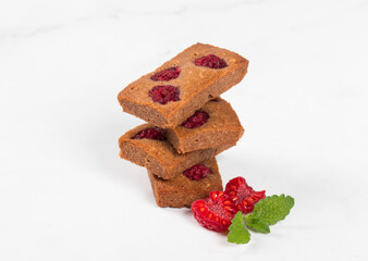Vegan French cookie. Financier. Chocolate almond cookies with raspberries. White background. Close-up