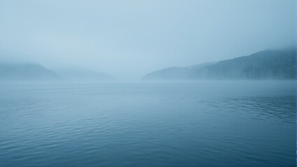 Fototapeta premium Tranquil lake with gentle rain ripples and misty mountains in the background Serene nature landscape for calming visuals