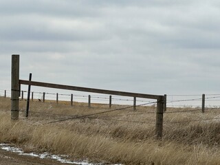 farm fencing used to enclose open fields and livestock pasture in rural Alberta, Canada.