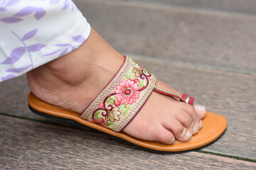 Naklejka premium A lady wearing sandals that has flowers on it