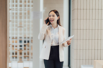 Smiling Asian Businesswoman Talking on Phone in Office